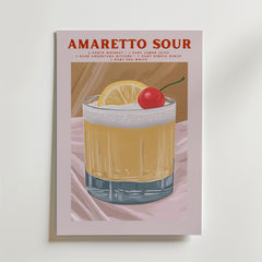 Bozetto Amaretto Sour Cocktail Poster är tryckt på premiumpapper med en lyxig matt finish och föreställer ett glas garnerat med citron och körsbär. Receptet visas i rött ovan på en ljusrosa bakgrund.