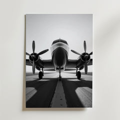 Bozetto Vintage Airplane Poster visar ett svartvitt propellerflygplan på landningsbanan framifrån med båda motorerna synliga. Tryckt på FSC-certifierat premiumpapper med lyxig matt yta.