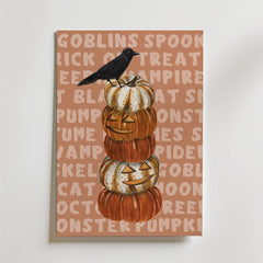 Bozetto Pumpkin Tower Poster föreställer fem snidade pumpor staplade på varandra och toppade med en svart kråka, mot en solbrun bakgrund med blekta Halloweenord - perfekt för höstmyset.