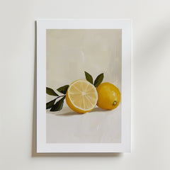 Bozetto Minimal Lemon Poster visar en hel och en halv citron med gröna blad på en ljus bakgrund i en vit ram, vilket ger elegans och modern stil till alla rum.