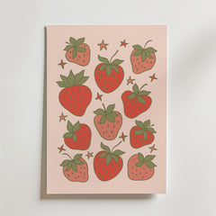 Bozetto Cute Strawberries Poster föreställer nio illustrerade jordgubbar, gröna blad och små gula stjärnor på en ljusrosa bakgrund - perfekt för retroinredning eller köksdekoration.