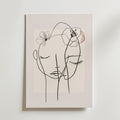 Bozetto Floral Line Faces Poster har minimalistisk svart linjekonst av två ansikten med slutna ögon och delikata blomsterskisser på en ljus beige matt yta, vilket skapar en lugn och intim atmosfär.