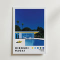 Bozetto Hiroshi Nagai Poolside Harmony Poster föreställer ett minimalistiskt hus med en pool bland träd under en djupblå himmel. Djärva färger och enkla former framkallar ett tidlöst lugn. Text: "Hiroshi Nagai, Tokyo 1973.