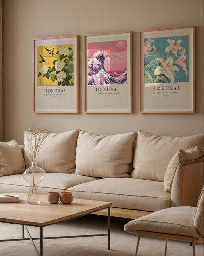Ett mysigt vardagsrum med en beige soffa, soffbord i ljust trä och Bozettos Bundle 3-pack Hokusai No. 1-tavlor inramade ovanför. En glasvas med torkade grenar på bordet ger inredningen en japansk konstkänsla.