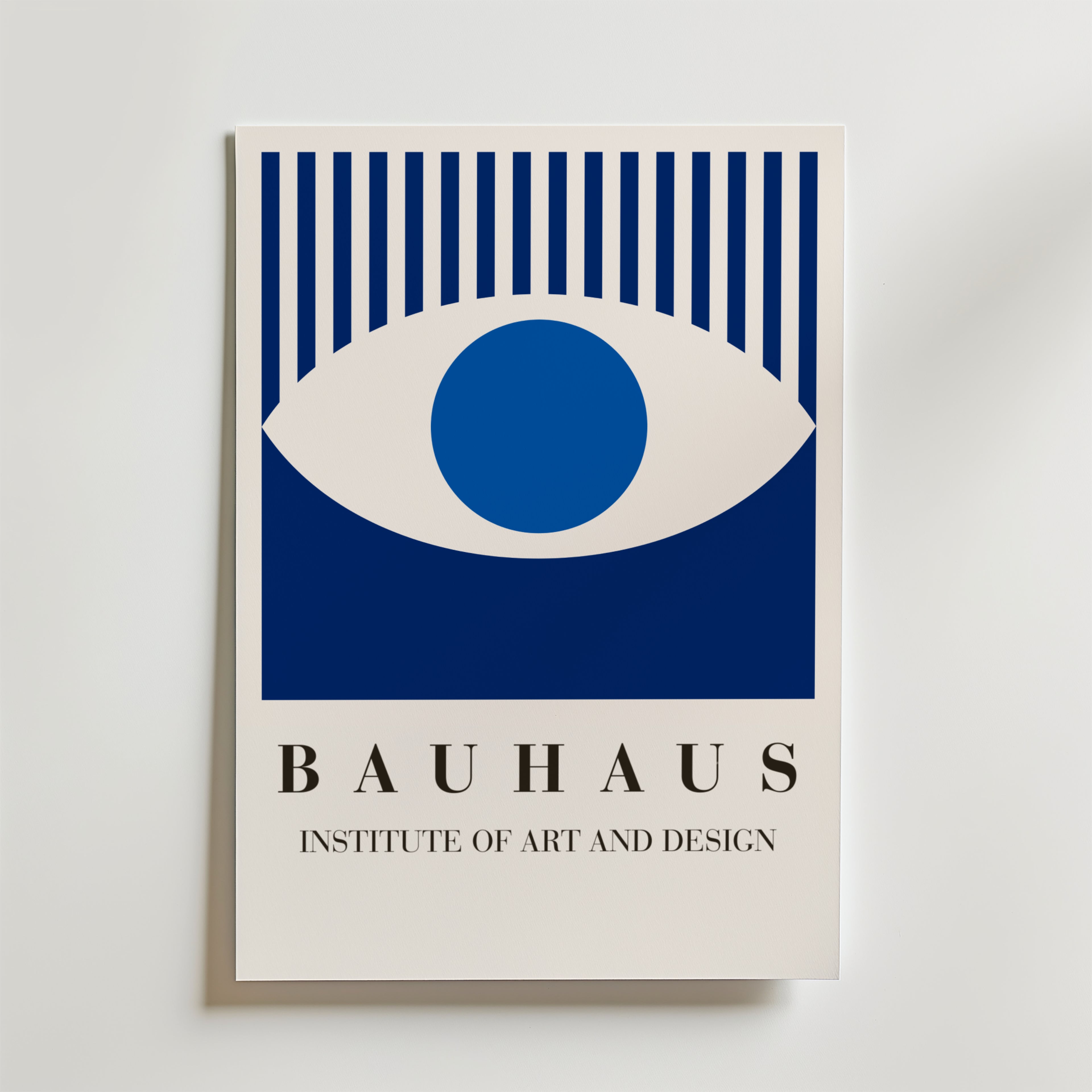 Bauhaus Blue Eye Poster från Bozetto visar ett blått och vitt abstrakt öga ovanför "BAUHAUS INSTITUTE OF ART AND DESIGN" i feta, moderna typsnitt på en ljus bakgrund, tryckt på premiumpapper med en lyxig matt finish.
