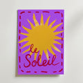 Bozetto Le Soleil Sun Poster har en ljusgul sol med vågiga strålar på en lila bakgrund, röd kursiv "Le Soleil" text och en röd streckad kant - perfekt som en färgstark konst solmotiv poster.