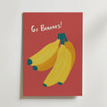 Go Bananas Poster från Bozetto har tre bananer med gröna toppar på en röd bakgrund, lekfull "Go Bananas!"-text i vitt och är tryckt på högkvalitativt premiumpapper för unik väggkonst.