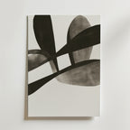 Bozetto's Abstract Leaves Art Poster har överlappande svarta och grå organiska former på vit botten, tryckt på premiumpapper. Denna moderna, minimalistiska poster ger unik väggkonst till alla utrymmen och visas fotograferad mot en ljus vägg.