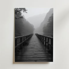 Infinity Bridge Poster av Bozetto föreställer en träbro som övergår i dimmiga träd och berg, med en ensam figur i slutet - perfekt för att skapa en harmonisk atmosfär i alla rum.