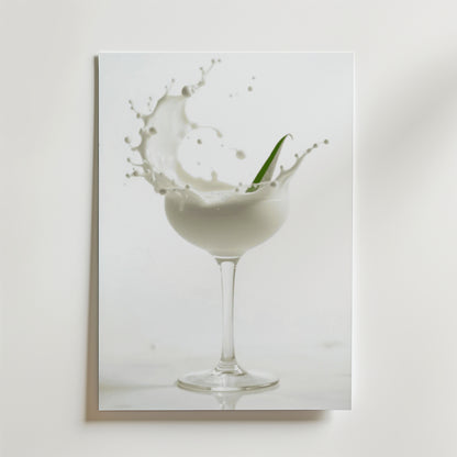 En skvätt mjölk sprutar ur en glasbägare med ett grönt blad hängande i luften, på en vit bakgrund - en elegant Bozetto Foam Champagne Drink Poster, tryckt på premiumpapper med lyxigt matt yta.