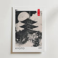 Bozetto Kyoto Temple Poster har en svartvit illustration av Kyotos pagod under fullmåne, moln och "KYOTO" nedanför, med en röd etikett med japansk text uppe till höger, vilket framhäver elegant österländsk estetik.