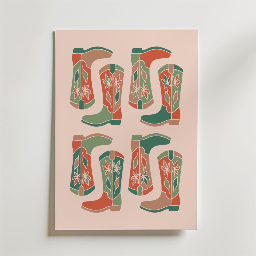Boot Parade Poster by Bozetto har ett retro rutnätstryck av fyra par stiliserade cowboystövlar - sex stövlar - i grönt, rött och beige med enkla blommor på en ljusrosa bakgrund.