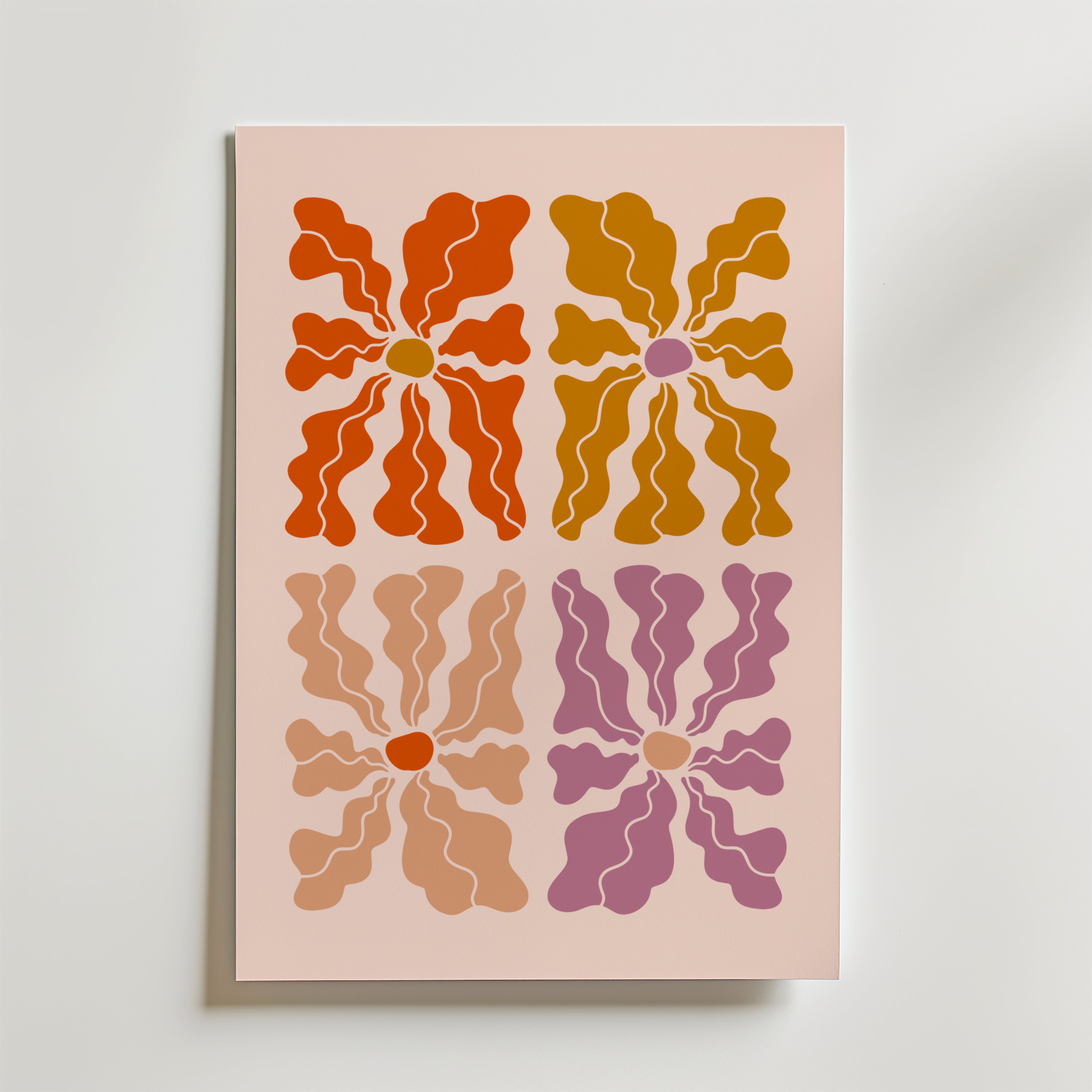 Petal Variations Poster från Bozetto visar fyra abstrakta blommor - rödorange, senapsgul, beige och mauve - i ett 2x2 rutnät på ljusrosa. Varje blomma har en rundad mitt och strålande kronblad i mjuka, vågiga nyanser.