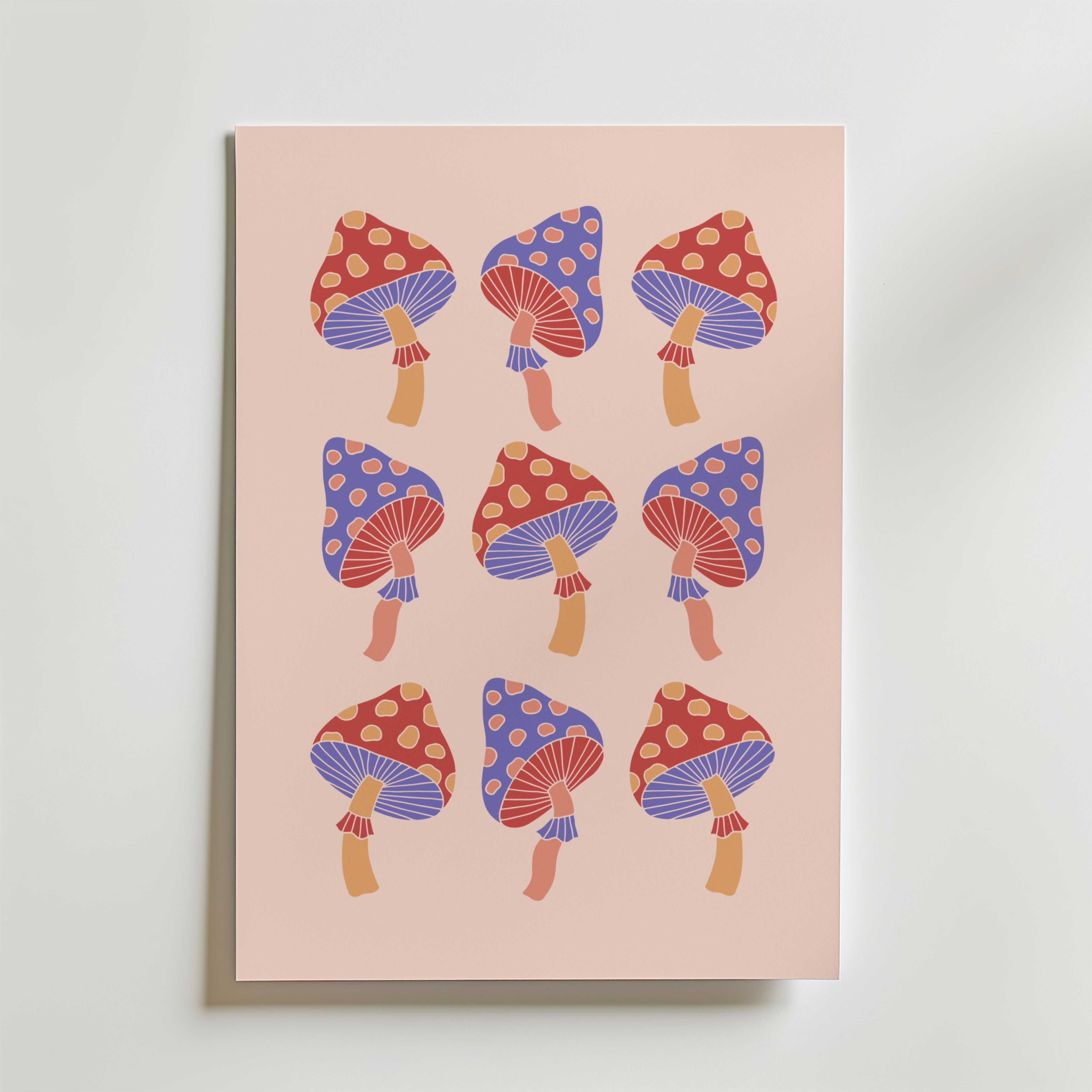 Bozetto Psychedelic Mushrooms Poster har ett rutnät med nio retrosvampar med röda och blå hattar, gula fläckar och lilarandig undersida på en ljusrosa bakgrund - perfekt för bohemisk inredning.