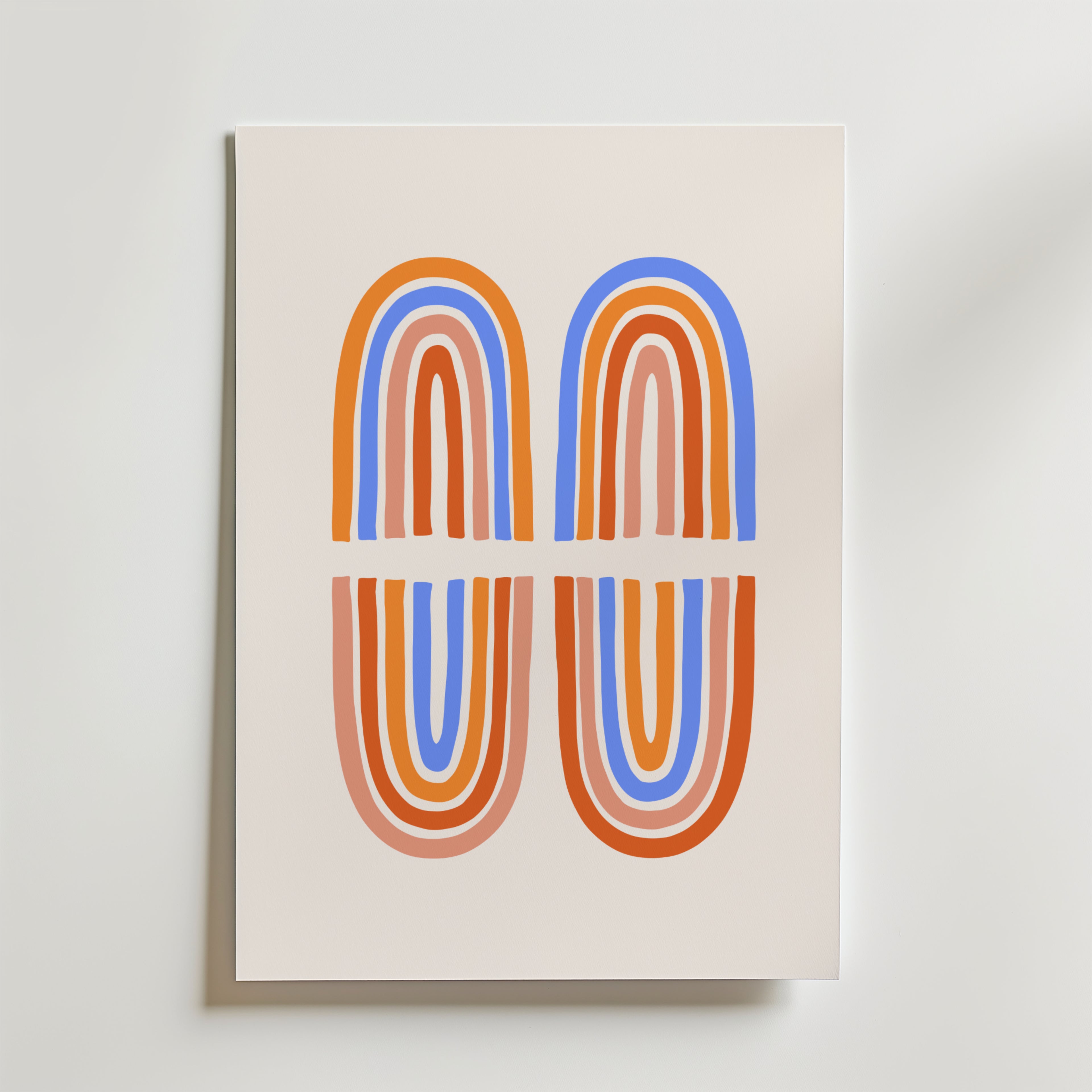 Double Arch Harmony Poster från Bozetto har två speglade bågar i lager av orange, röda, blå och beige linjer på en ljus bakgrund - en modern väggkonst som passar perfekt för färgstarka interiörer.