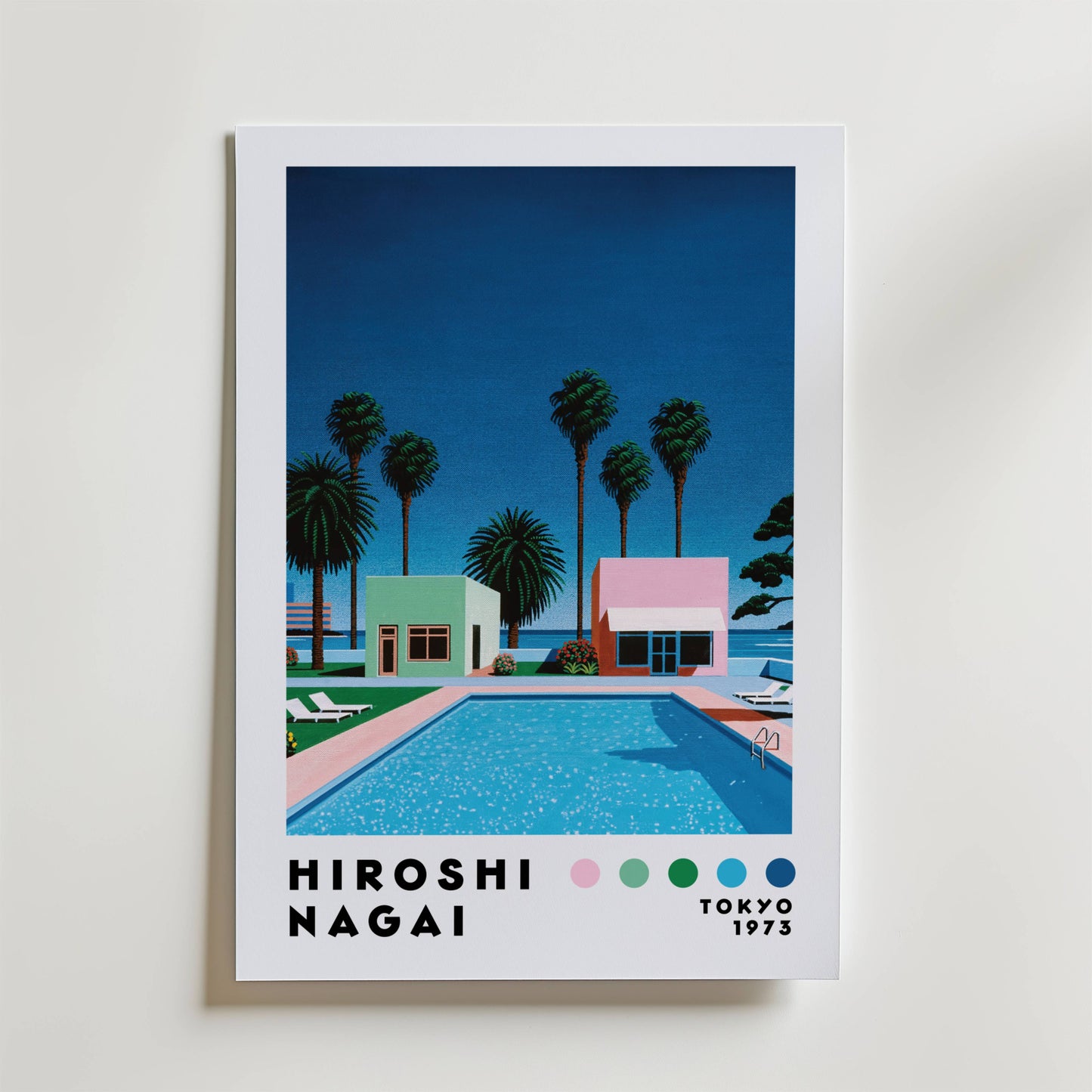 Bozetto Hiroshi Nagai Palm Springs Pool Poster visar en pulserande poolscen från mitten av århundradet med palmer och pastellfärgade bungalows under en djupblå himmel. "Hiroshi Nagai, Tokyo 1973" och fem färgprover visas längst ner - en blinkning till sommarens avkoppling.