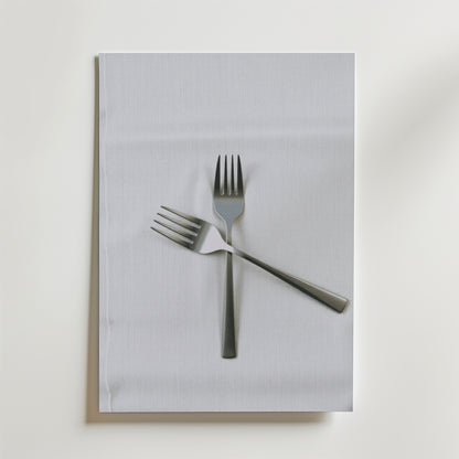 Två metallgafflar korsade i en X-form vilar på en vit tygservett ovanpå en vit yta - en elegant komposition som visas på Bozetto Classic Forks Poster.