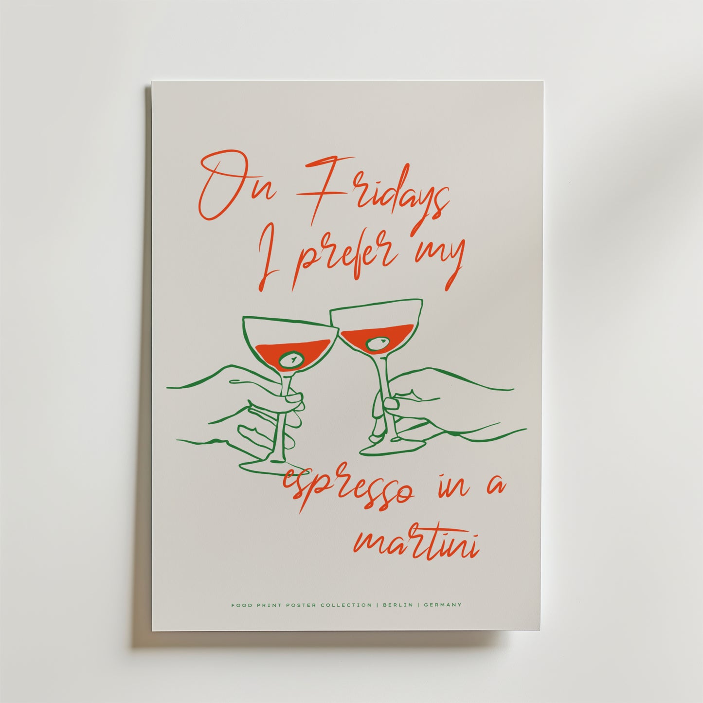 Affischen Friday Espresso Martini Poster från Bozetto visar två illustrerade händer som klirrar i espresso martini glas, med röda och gröna linjer på en vit bakgrund och texten: På fredagar föredrar jag min espresso i en martini.