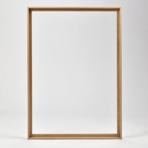 Bozetto Canvas Träram Ek är en enkel, tom tavelram i trä med en exklusiv träram, som står upprätt mot en vit bakgrund.