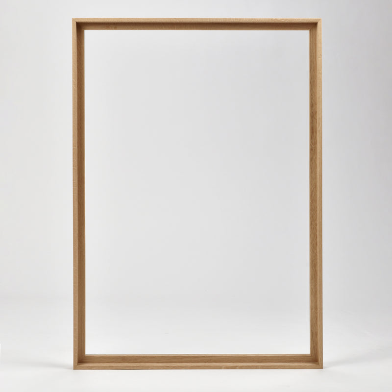 Bozetto Canvas Träram Ek är en enkel, tom tavelram i trä med en exklusiv träram, som står upprätt mot en vit bakgrund.