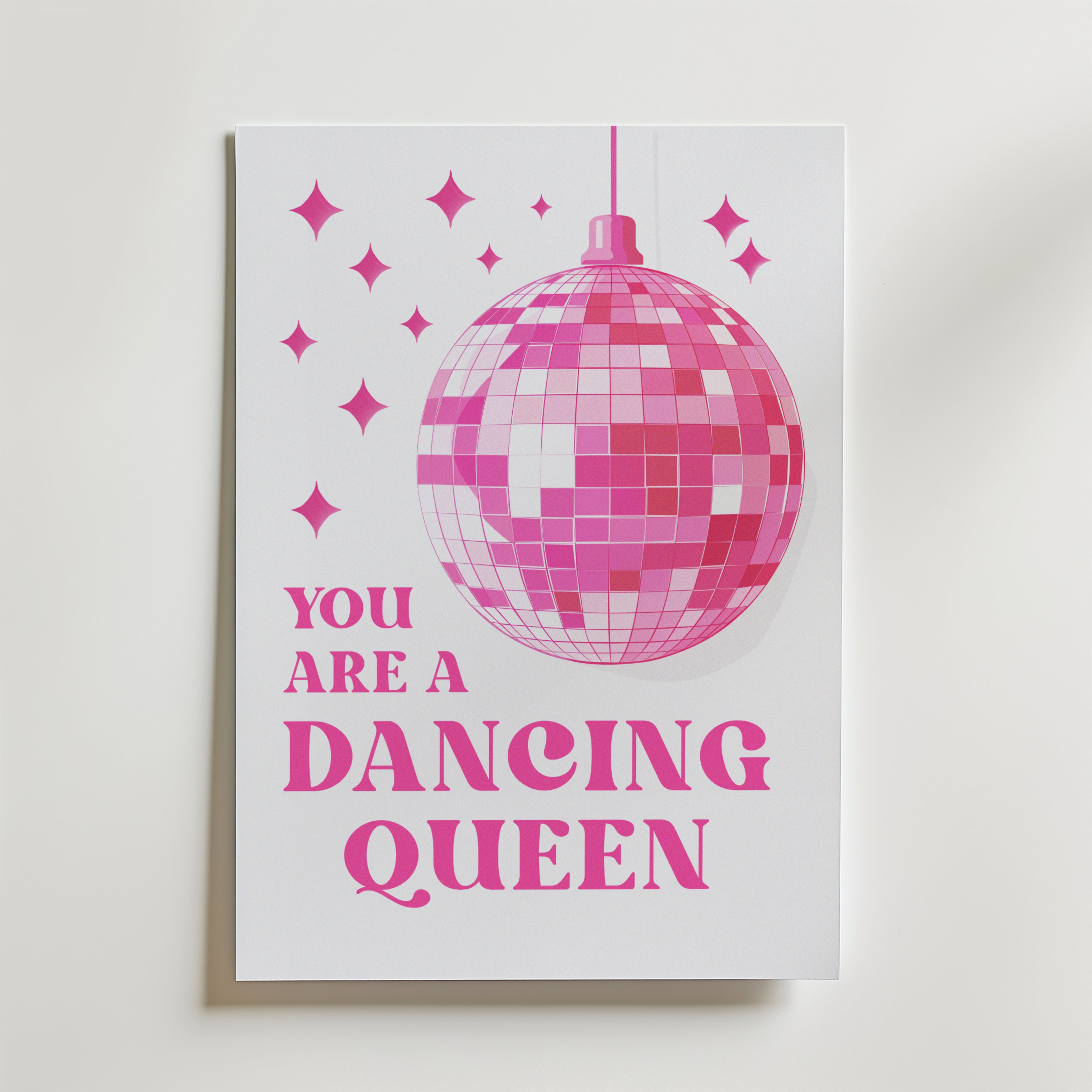 Bozetto Dancing Queen Disco Poster föreställer en stor rosa discokula och gnistrande stjärnor med texten "You are a Dancing Queen" i rosa nyanser. Den vita bakgrunden gör den perfekt för ett färgstarkt hem.