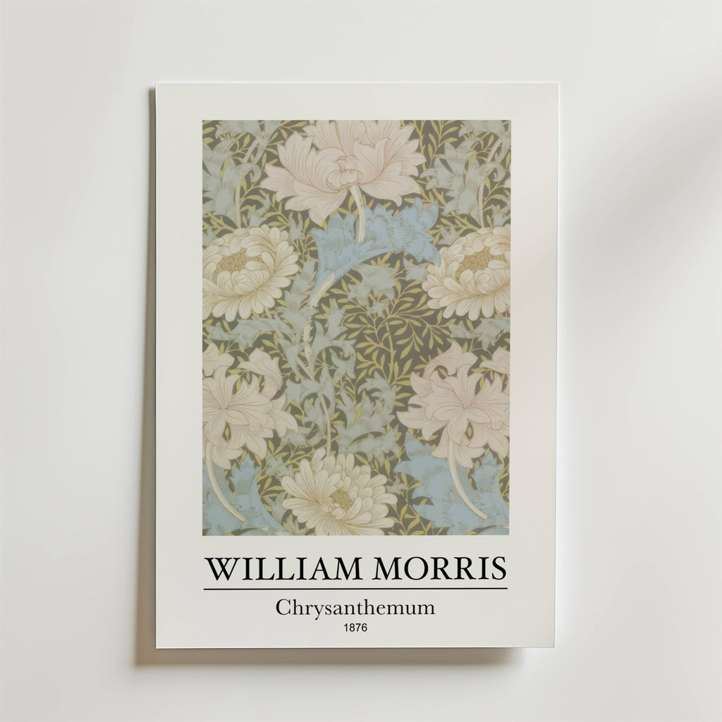 Bozetto William Morris Chrysanthemum Poster visar den intrikata blomsterdesignen från 1876 i mjukt grönt, krämfärgat och blått på en himmelsblå bakgrund med texten "WILLIAM MORRIS Chrysanthemum 1876" under bilden.