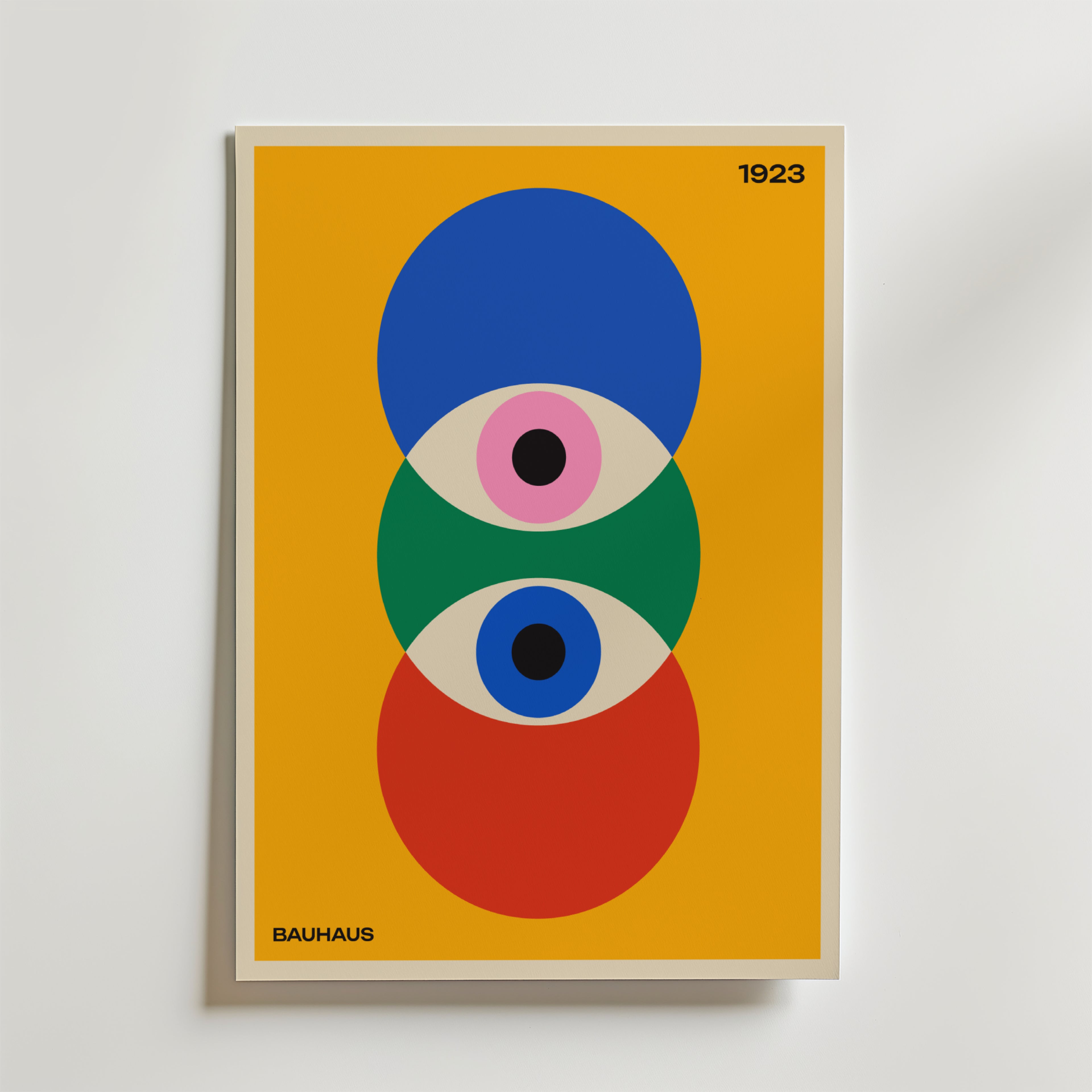 Bozetto Bauhaus Trinity Poster föreställer överlappande blå, gröna och röda cirklar med stiliserade ögon på en gul bakgrund. "1923" står högst upp till höger och "Bauhaus" står längst ner till vänster.