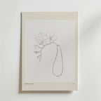 Minimalistisk konstlinjeteckning av en blomma med långt blad på postern "Soft As Silence" från Bozetto, beige-kanterad mot vit vägg. Enkel och elegant design med texten Botanical Gallery längst ner.