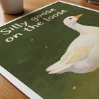 Silly Goose affisch liggande på skrivbord – Bozetto konsttryck i hög kvalitet